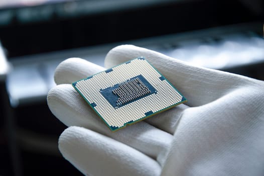 An image of a technician holding a CPU in his hand.
