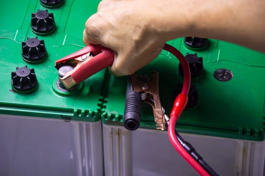 Top view, mechanic working with battery tweezers