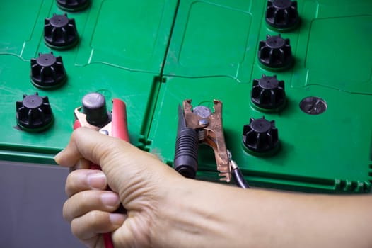 mechanic working with battery tweezers
