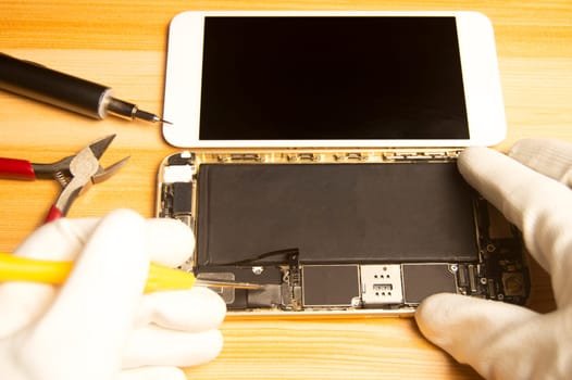Top view of a technician repairing a smartphone