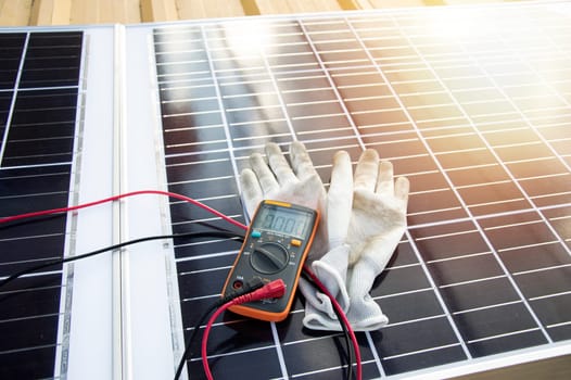 Multimeter and glove pictured on solar panel