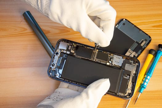 Top view of a technician repairing a smartphone