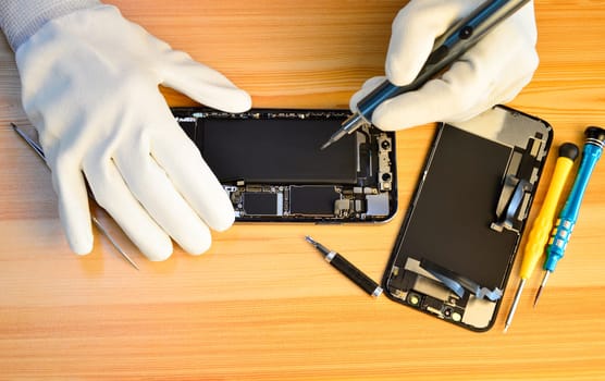 Top view of a technician repairing a smartphone