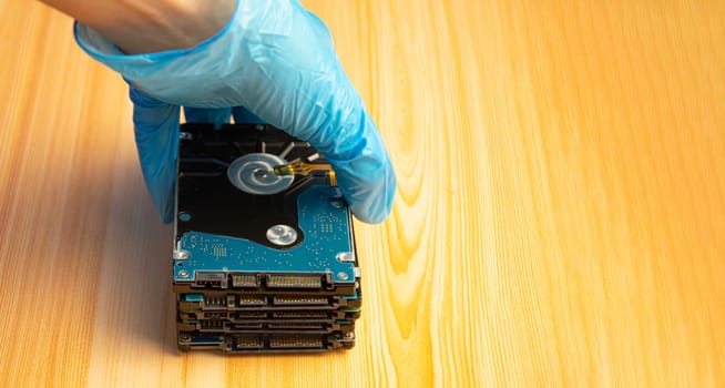2.5-inch hard drives stacked on top of each other with a brown wooden background.