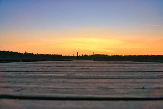 Wooden jetty at sunset on a Swedish lake. Romantic evening atmosphere. Scandinavian nature