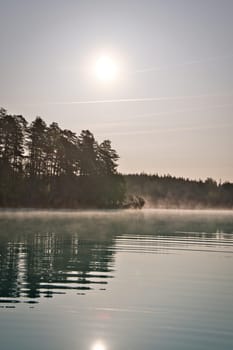 Sunrise with fog forming over a lake in Sweden, at dawn. Romantic silence, in the Scandinavian nature