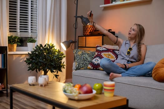 A young woman is enjoying a cozy and relaxed evening in her stylish living room, capturing a truly peaceful moment