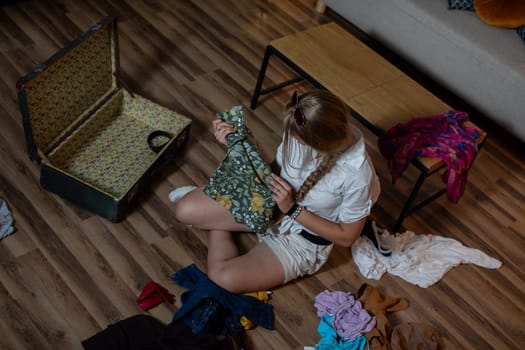 A young woman diligently sorting through a variety of colorful clothing while carefully organizing her fashion items