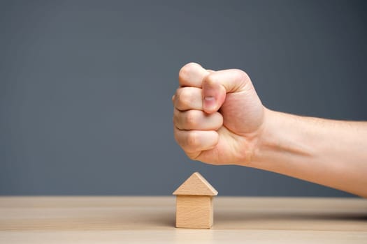 The fist aims at the house. Сollectors. Concept of threat to house and real estate and business. The threat of a strike at prices. Aggression on the market.