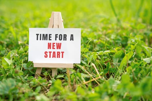Time for a new start concept. Motivation, self-motivation and startup concept. Launch of a new project. Business planning and strategy. Easel with inscription on green grass
