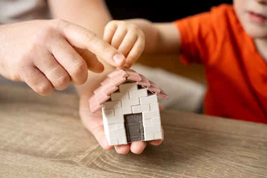 A father gives his son a small house. The concept of transfer of property and inheritance. Real estate. housing as a gift, apartment or house