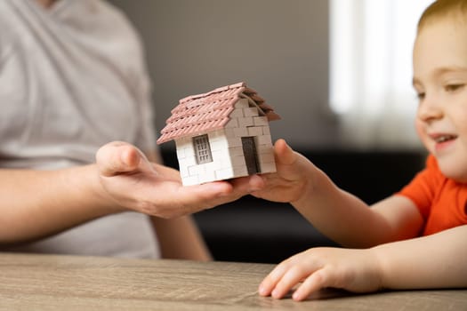 A father gives his son a small house. The concept of transfer of property and inheritance. Real estate. housing as a gift, apartment or house