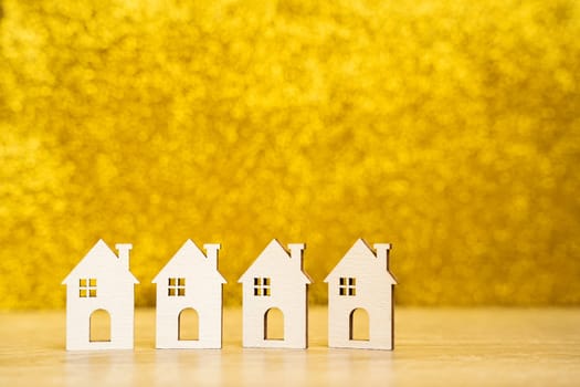Wooden houses on a yellow background. Real estate and affordable housing concept. Mortgage, loan and insurance of apartments. Selling and buying home. Copy space