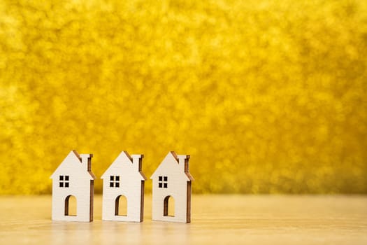 Wooden houses on a yellow background. Real estate and affordable housing concept. Mortgage, loan and insurance of apartments. Selling and buying home. Copy space