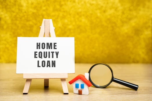 Home equity loan concept. Type of loan in which the borrowers use the equity of their home as collateral. Easel, house and magnifying glass. Real estate and credit