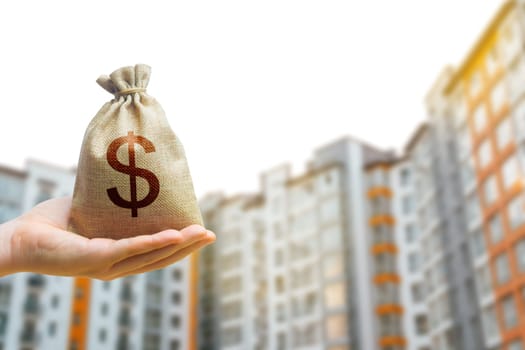 Dollar bag against the background of modern high-rise buildings. Investing in the purchase of real estate. Affordable housing and mortgage rates. Renting apartments and houses. Residential complex.
