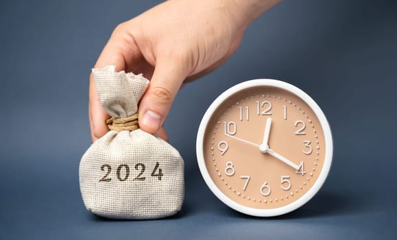 Money bag 2024 and clock. Budget planning. Financial goals and plans. Business and finance concept. Forecasting and analysis. Investments. Vision