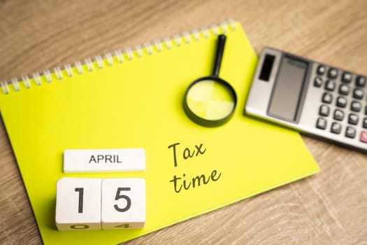 15 april - tax time concept. Taxpaying, business and finance. Notes, magnifying glass and calculator