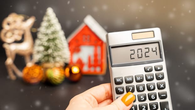 Calculator 2024, Christmas tree and miniature houses. Accumulating money and planning a budget. Business and finance. Loans, deposit, credit. Promotions, offers.