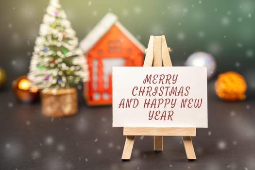 Easel with the words Happy New Year and Merry Christmas. New Year or Xmas winter holiday. Decoration, celebration. The concept of the beginning of the new year. Snow, snowfall