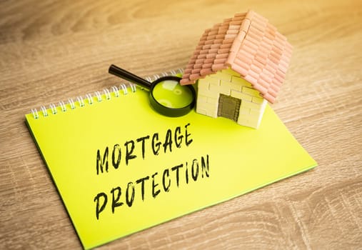Mortgage protection concept. Insurance policy that pays out in the event of death or when you are unable to work. Real estate, business and finance concept. House and magnifying glass