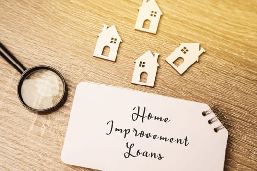 Home improvement loans concept - personal loans used specifically for financing repairs, renovations and remodels. Investing money in real estate. Miniature houses and magnifying glass