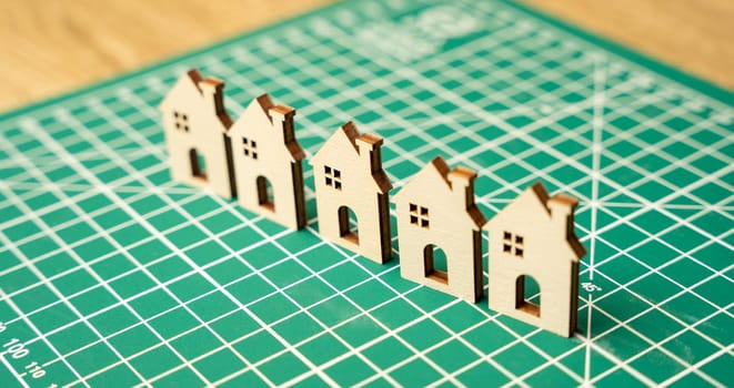 Miniature houses on a cutting mat. Home renovation and reconstruction concept. Construction of real estate and new housing. Maintenance house. Close up, selective focus
