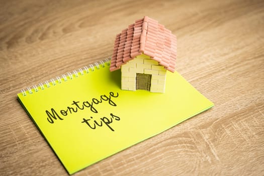 Inscription Mortgage tips in a notebook. Tips for getting a loan to buy a home. Affordable housing for young families. Real estate and finance concept