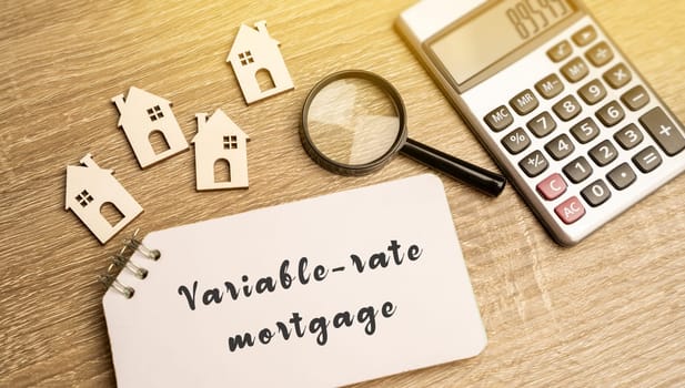 Variable-rate mortgage concept. Type of home loan in which the interest rate is not fixed. Real estate, business and finance concept. Miniature houses, magnifying glass and notes