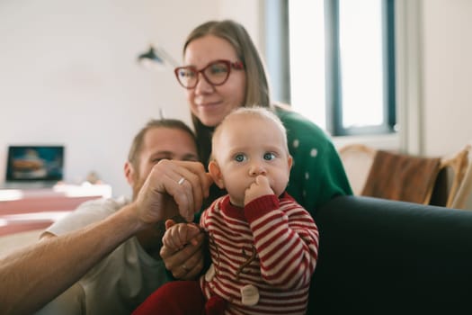 A heartwarming family scene captures a mother, father, and their baby joyfully sharing memorable moments together