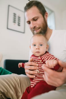 A joyful and caring father holds his precious baby tightly, creating a beautifully warm family moment indoors