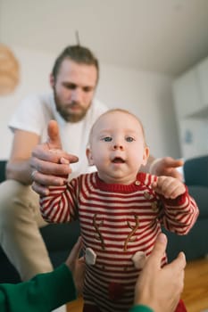 A truly precious moment takes place as a baby makes their very first steps with loving guidance in a cozy home