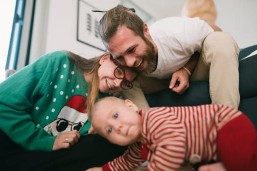 A happy family captures a fun moment with their adorable baby at home, showcasing their love and bond