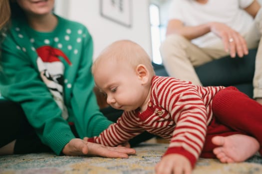 A cheerful baby is exploring on the floor, surrounded by a loving family in a festive, exciting atmosphere