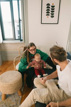 A loving family sharing a delightful and warm moment together with their adorable baby in a stylish home setting