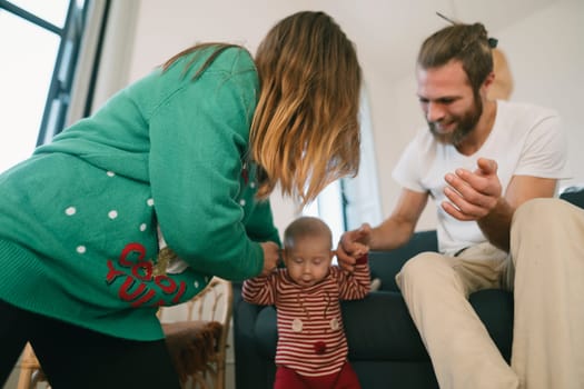 A joyful family captures a truly precious moment together as their adorable toddler experiences learning to walk