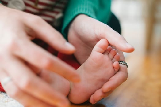 This heartwarming moment beautifully captures a loving parent gently cradling their babys tiny foot with affection