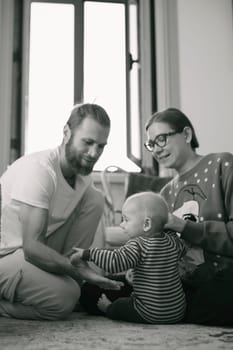 A heartwarming family scene showcasing a baby enjoying precious moments with loving parents in a cozy indoor space