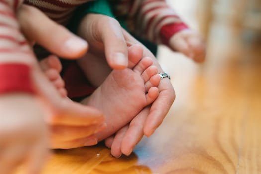 A heartwarming moment of parental care is captured, showcasing nurturing hands gently on a babys tiny feet