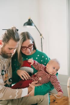 A delightful and joyful family scene celebrating Christmas together with a lovely baby in festive attire
