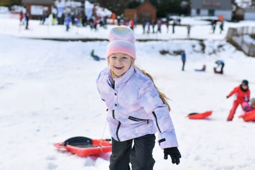 A girl with bob sledding in the snow in the mountains