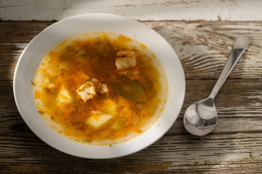 A heartwarming dish features tender fish and vegetables simmered in rich broth, inviting comfort on a chilly day.