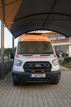 Gaziveren Cyprus -30.01.2025 An ambulance rests under a shelter at dusk, awaiting its next call for assistance in a serene environment.