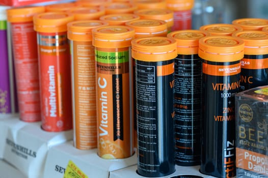Bright vitamin tubes draw health-conscious shoppers in a lively marketplace.