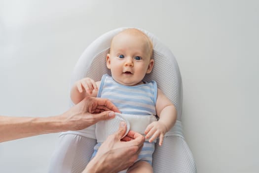 Adorable 3-month-old baby lying safely in a cozy infant cocoon secured with a special safety belt. Comfortable and protective design for newborn care. Parenting, safety, and baby comfort concept.
