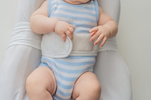 Adorable 3-month-old baby lying safely in a cozy infant cocoon secured with a special safety belt. Comfortable and protective design for newborn care. Parenting, safety, and baby comfort concept.