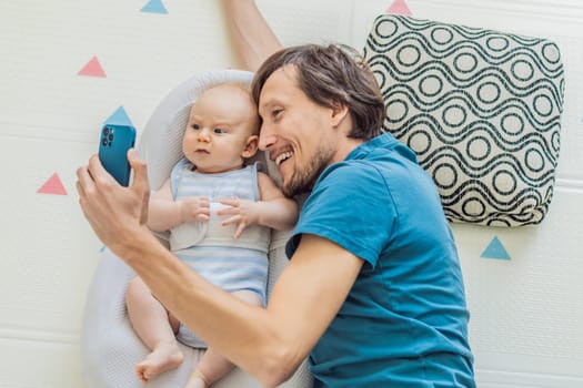 A 3-month-old baby lies safely in a cozy infant cocoon, secured with a special safety belt, while their father lies beside them during a video call. Modern parenting, bonding, and technology concept.