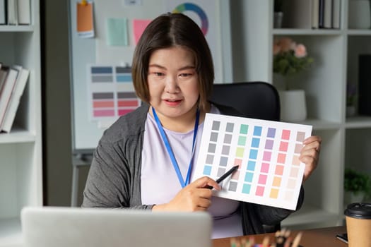A graphic designer enthusiastically showcases a selection of color swatches, discussing their application in branding and visual identity projects during a design meeting.