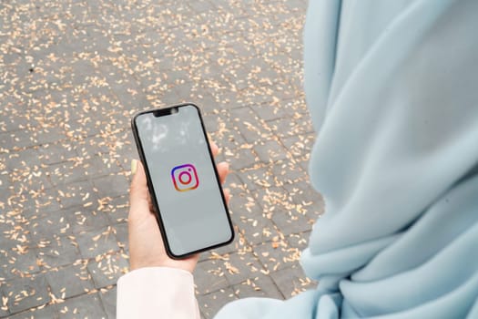 A woman holds Apple iPhone 14 with Instagram application on the screen. Instagram is a photo-sharing app for smartphones