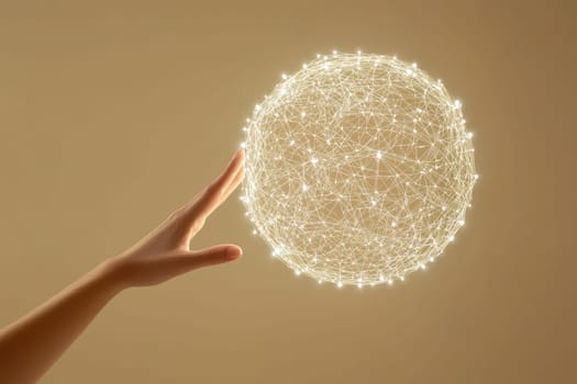 A hand is holding a glowing sphere that is surrounded by a web of lines. The sphere appears to be a representation of a network or a connection between people. Concept of unity and interconnectedness